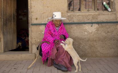 La boliviana nunca se casó ni tuvo hijos, ahora son su sobrina-nieta, Agustina Berna, de 65 años, y su hija Rosa Lucas quienes supervisan a la anciana. En imagen, ‘mama Julia’ juega en la puerta de su casa con ‘Chiquita’, uno de los perros de la familia.