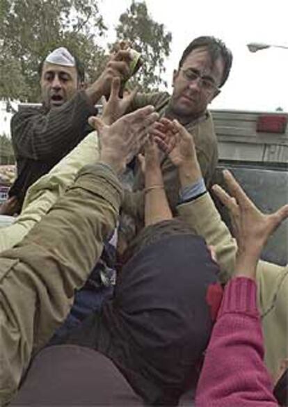 Miembros de los grupos de socorro iraníes distribuyen alimentos entre la hambrienta población de Bam.