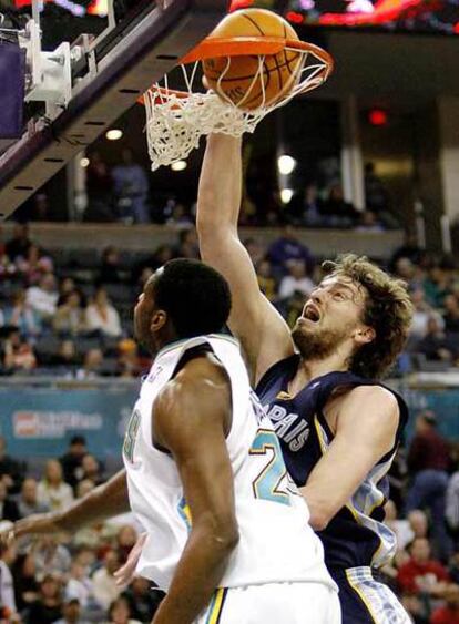 El ala-pívot Pau Gasol machaca ante la presencia del jugador de los Hornets Desmond Mason.