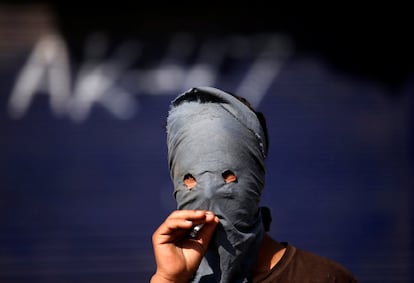 Un manifestante enmascarado fuma un cigarro durante una protesta contra la reciente muerte de un civil, en Srinagar, Cachemira India.