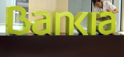 Una operaria limpia el logo de Bankia. EFE/Archivo