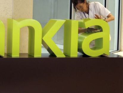 Una operaria limpia el logo de Bankia. EFE/Archivo