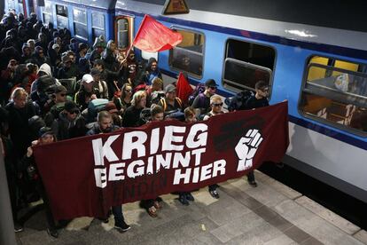 Un grupo de activistas marcha con una pancarta que lee "La guerra comienza aquí" en la estación central de tren de Hamburgo.