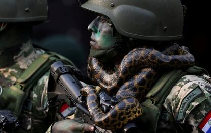 Un miembro de las fuerzas especiaes de Paraguay marcha con una serpiente enroscada en su cuello frente al presidente de la nación, Mario Abdo Benítez durante un desfile militar en Asunción (Paraguay).