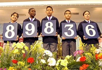 Los niños de San Ildefonso muestran el primer premio del sorteo extraordinario de la lotería de <i>El Niño</i>.