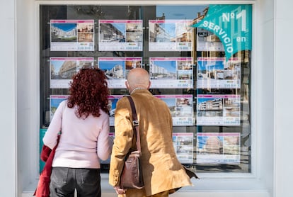 Una pareja observa el escaparate de una agencia inmobiliaria en Alicante en 2022.