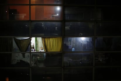 Cuando la torre fue abandonada, la construcción estaba lo suficientemente avanzada en los primeros 28 pisos como para ser habitable. En la imagen, un hombre en el interior de su apartamento junto a su familia.