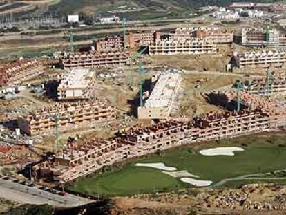 Vista aérea de viviendas en construcción y de un campo de golf en la localidad malagueña de Manilva, cuya población ha crecido un 87,6% en nueve años.