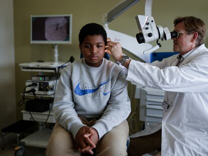 El jefe del servicio de Otorrinolaringología del Hospital Sant Joan de Déu, Oliver Haag, inspecciona el oído de Aissam Dam.