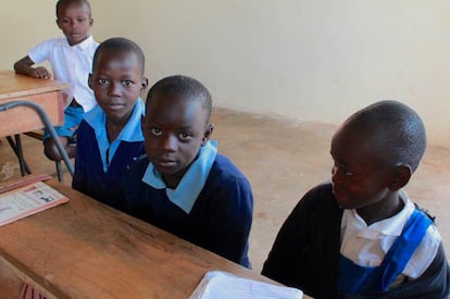 Byron, junto a sus dos compañeros de pupitre en la escuela de Kabondo.