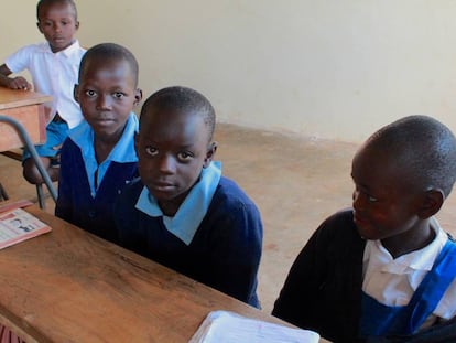 Byron, junto a sus dos compañeros de pupitre en la escuela de Kabondo.