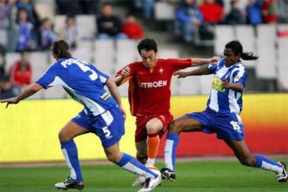 Los jugadores del Español Mauricio Pochettino (i) y Fredson Camara (d) bloquean a Fabian Canobbio, del Celta.