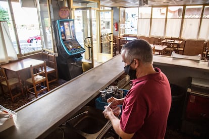 Un camarero seca varios vasos en un bar de Badajoz (Extremadura).