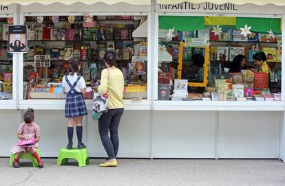 Dos niñas hojean libros en la Feria del Libro de Madrid.