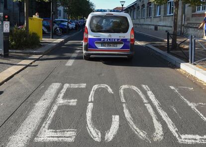 Un coche de policía patrulla frente a una primaria en Burdeos por el inicio del ciclo escolar.
