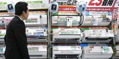 Un hombre pasa frente a un comercio en Japón