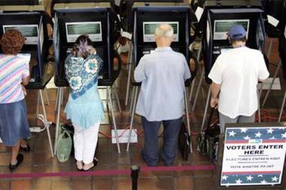 Votantes de Florida, en las cabinas de un centro electoral ayer en Miami.