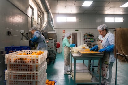 Tres trabajadoras de la empresa NaturSnacks preparan la fruta deshidratada.