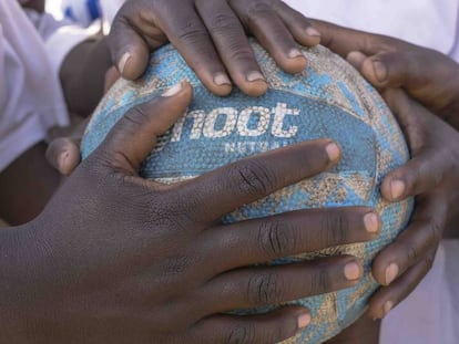 Las jugadoras de Mthulu, ganadoras del campeonato, sujetan en balón después del partido, en Malawi.