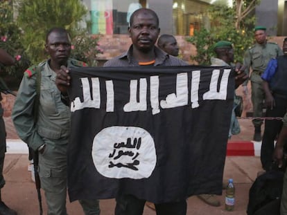Agentes maliense muestran una bandera yihadista hallada en un hotel de Bamako, atacado en noviembre de 2015.