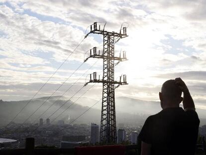 Una persona observa el cableado con el que red eléctrica transporta la energía sobre la ciudad de Bilbao.