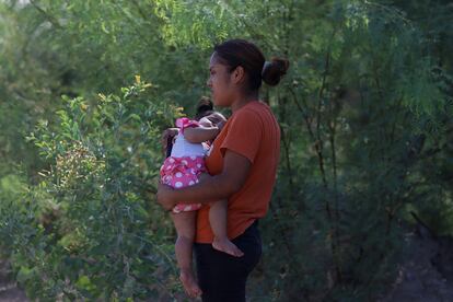 Una mujer con una niña en brazos espera noticias.