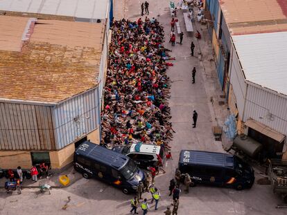 Menores extranjeros no acompañados, a las puertas de una nave usada como albergue provisional en Ceuta, el miércoles.