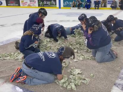 Un grupo de profesores de Dakota del Sur participa en un juego para recaudar dinero durante el intermedio de un partido de hockey sobre hielo.