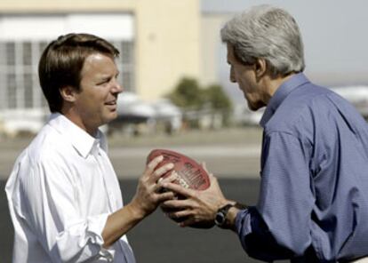 John Kerry entrega un balón de fútbol americano a John Edwards durante una sesión fotográfica en el aeropuerto de Alburquerque (Nuevo México).