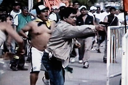 Un hombre apunta con una pistola en los choques entre peronistas ayer en San Vicente (Argentina).