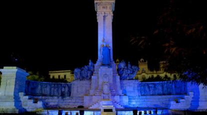 El monumento a las Cortes de 1812, en Cádiz, iluminado con luces azules.