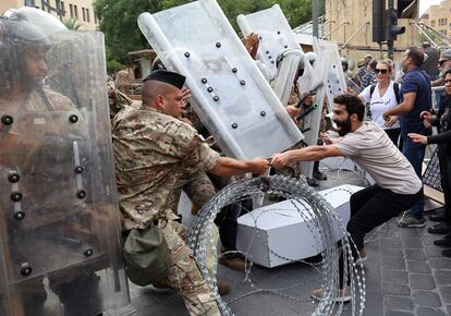 Centenares de personas tomaron parte este jueves
en tres marchas diferentes para demandar justicia para los más de 200 muertos y 6.500 heridos en la explosión ocurrida en Beirut hace hoy dos años, que confluirán esta tarde frente al puerto de la ciudad, donde se originó la deflagración. En la foto, activistas libaneses se enfrentan a soldados durante una manifestación en el centro de la capital, Beirut, este jueves.