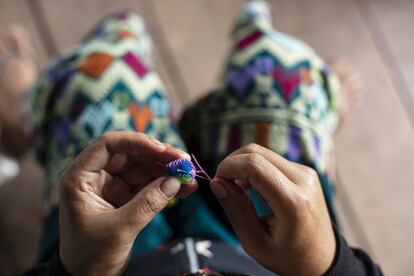 Yayer dedica un rato cada tarde a coser adornos típicos de su etnia.
