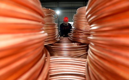 Un trabajador ata alambrones de cobre antes de cargarlos en un camión en una empresa en la provincia china de Jiangsu.