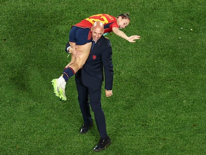 This picture taken on August 20, 2023 shows President of the Royal Spanish Football Federation Luis Rubiales carrying Spain's Athenea del Castillo Beivide on his shoulder as they celebrate winning the Australia and New Zealand 2023 Women's World Cup final football match between Spain and England at Stadium Australia in Sydney. (Photo by DAVID GRAY / AFP)