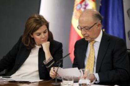 La vicepresidenta del Gobierno, Soraya Sáenz de Santamaría, y el ministro de Hacienda, Cristóbal Montoro, observan unos papeles durante una rueda de prensa tras la reunión del Consejo de Ministros. EFE/Archivo