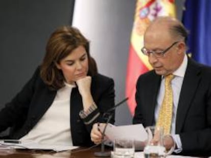 La vicepresidenta del Gobierno, Soraya Sáenz de Santamaría, y el ministro de Hacienda, Cristóbal Montoro, observan unos papeles durante una rueda de prensa tras la reunión del Consejo de Ministros. EFE/Archivo