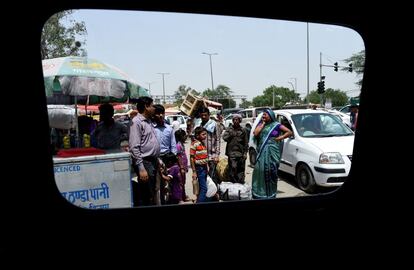 Una familia espera a un autobús en Bawana, India. 