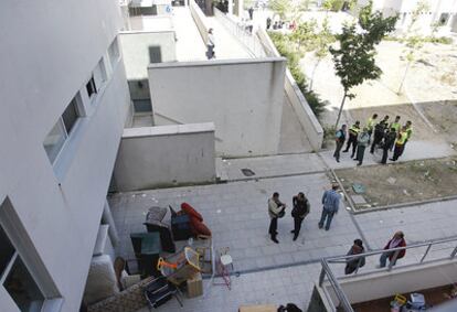 Un servicio de mudanzas saca los enseres que los okupas han dejado en las viviendas desalojadas en Navalcarnero bajo el control de los agentes de la Guardia Civil.