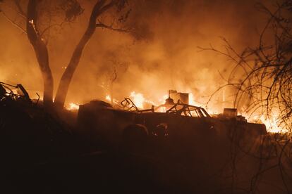 A pesar de los esfuerzos de las autoridades californianas, hasta ahora, poco más del 5% del incendio ha sido controlado. En la imagen, una estructura en llamas y un auto incendiado tras el paso del incendio Fairview.