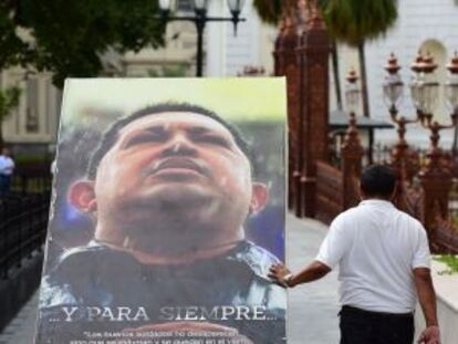 Operarios retiran ayer carteles del expresidente venezolano Hugo Chávez en la Asamblea.