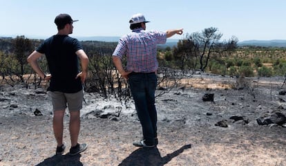 Unos vecinos observan los daños causados por el incendio de Ribera d'Ebre.