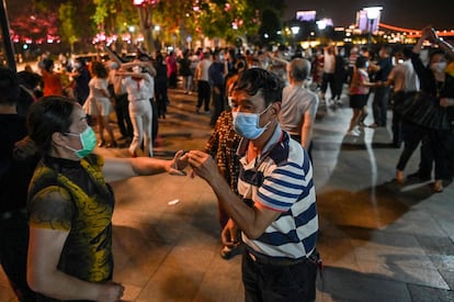 Parejas con mascarillas bailan en un parque junto al río Yangtzé, en Wuhan.