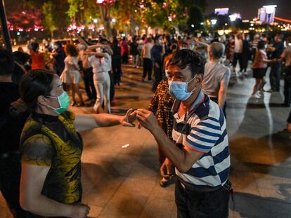 Parejas con mascarillas bailan en un parque junto al río Yangtzé, en Wuhan.