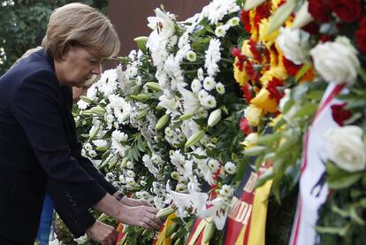 La canciller alemana, Angela Merkel, ante las coronas de flores que se han depositado en el lugar donde se ha conmemorado el 50 aniversario de la construcción del Muro de Berlín, en la calle Bernauer