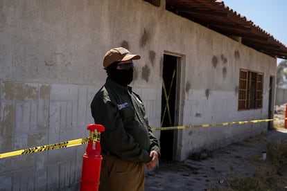 Un elemento de la fiscalía hace guardia al interior del rancho. 