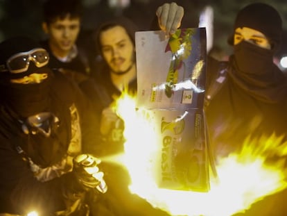 Manifestantes queimam um álbum de figurinhas da Copa.