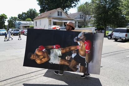 Un artista porta un cuadro del boxeador.