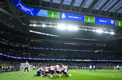 Vista general del estadio Santiago Bernabéu con los jugadores del Arsenal calentando.