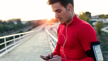 Un chico con el mvil que va a empezar a hacer running.